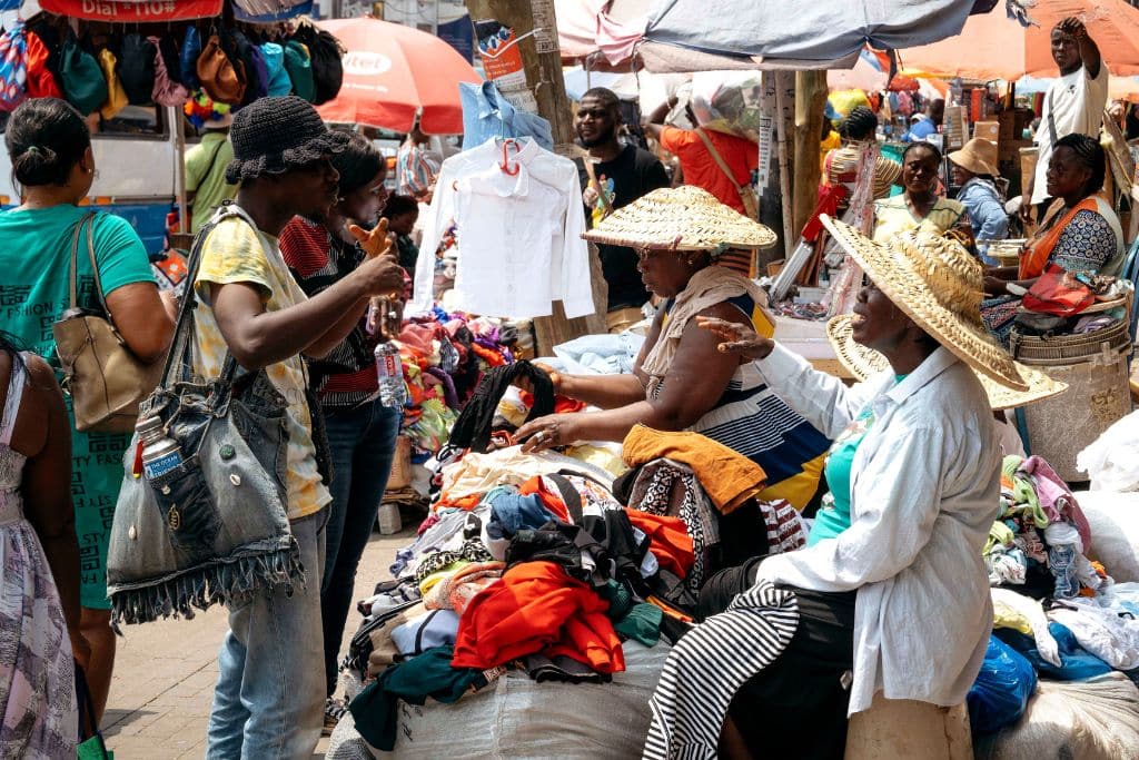Traders wearing hats seek refuge from Accra’s scorching sun.
