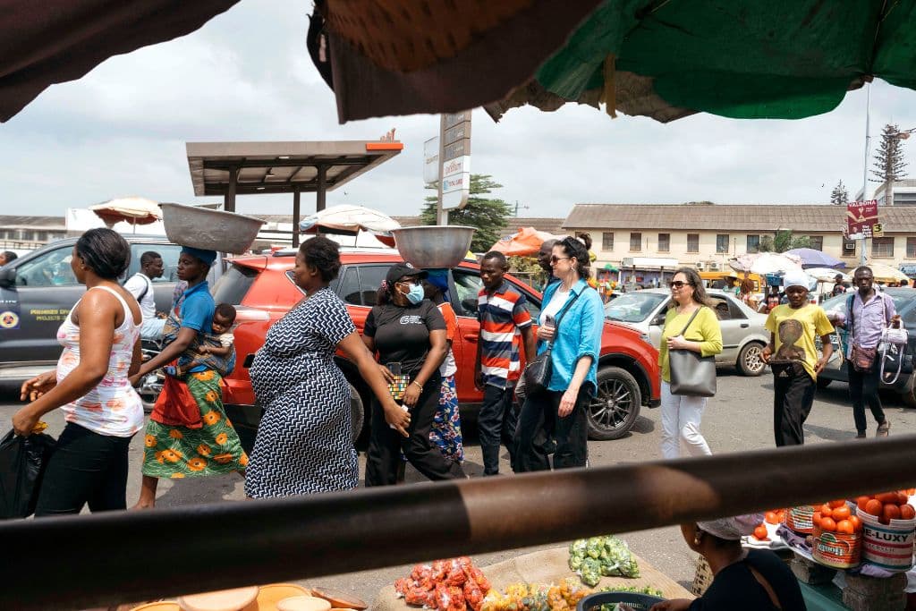 Women walk along a street market in Accra, Ghana.